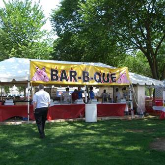 A tent with a sign depicting cartoon piggies and the word barbecue